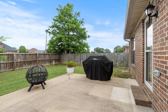 view of patio with area for grilling and a fire pit