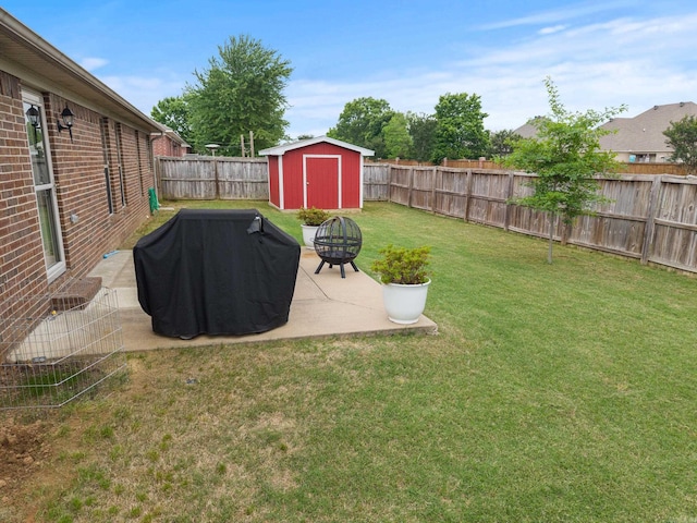 view of yard featuring a fire pit, a patio area, a storage shed, and an outbuilding