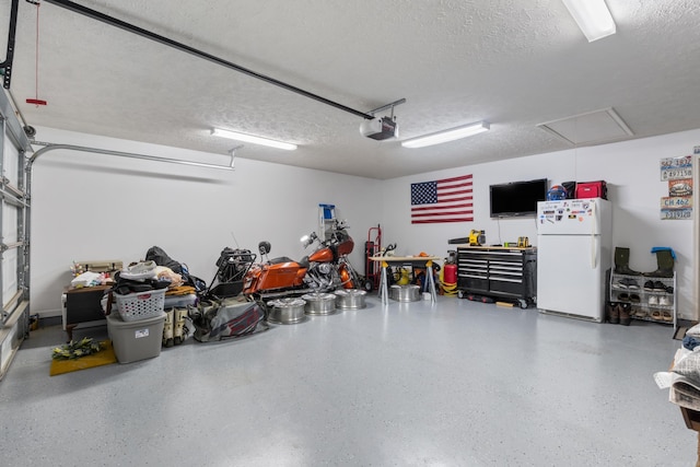 garage featuring freestanding refrigerator and a garage door opener