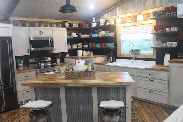 kitchen featuring wood counters, stainless steel appliances, open shelves, lofted ceiling, and wood walls