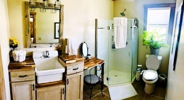 full bathroom featuring a stall shower, a chandelier, and toilet