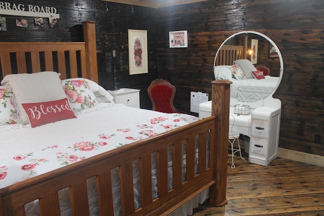 bedroom featuring wood finished floors and wooden walls