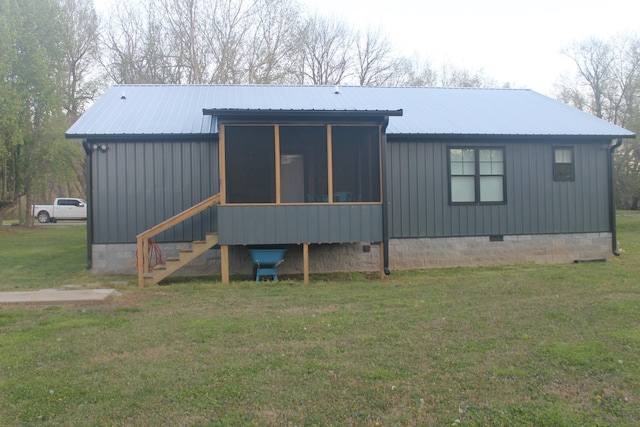 rear view of property featuring crawl space, a lawn, a sunroom, and metal roof