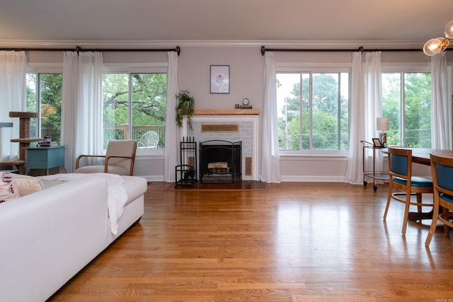 375 Goshen Ave, North Little Rock, AR 72116 - living area featuring crown molding, baseboards, a fireplace, wood finished floors, and healthy amount of natural light