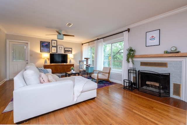 375 Goshen Ave, North Little Rock, AR 72116 - living room featuring crown molding, light wood-type flooring, ceiling fan, baseboards, and a brick fireplace
