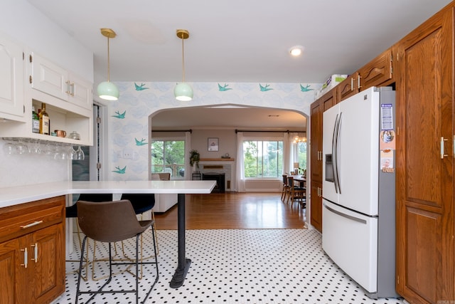 375 Goshen Ave, North Little Rock, AR 72116 - kitchen with white refrigerator with ice dispenser, arched walkways, wallpapered walls, light countertops, and a fireplace