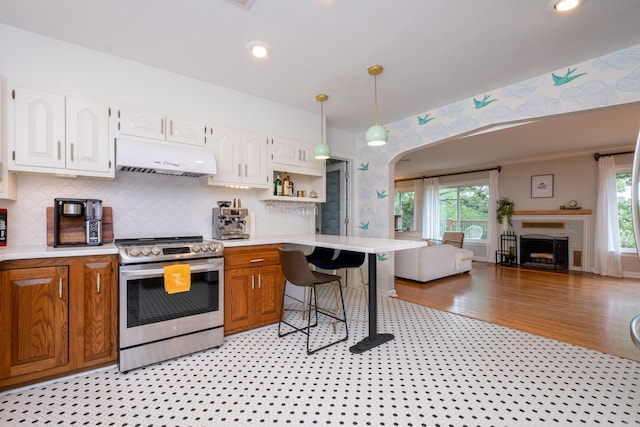 375 Goshen Ave, North Little Rock, AR 72116 - kitchen featuring stainless steel range with gas cooktop, extractor fan, light countertops, open floor plan, and arched walkways