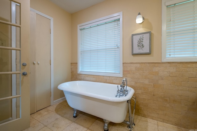 375 Goshen Ave, North Little Rock, AR 72116 - full bathroom featuring tile patterned floors, a freestanding bath, healthy amount of natural light, wainscoting, and tile walls