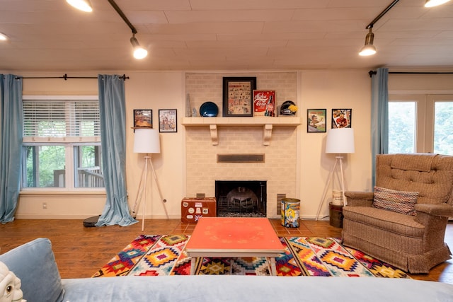 375 Goshen Ave, North Little Rock, AR 72116 - living room featuring rail lighting, a brick fireplace, baseboards, and healthy amount of natural light