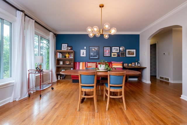375 Goshen Ave, North Little Rock, AR 72116 - dining space featuring arched walkways, crown molding, light wood-style flooring, a chandelier, and baseboards