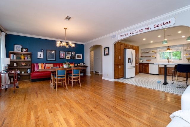 375 Goshen Ave, North Little Rock, AR 72116 - dining room featuring arched walkways, light wood finished floors, crown molding, and a chandelier