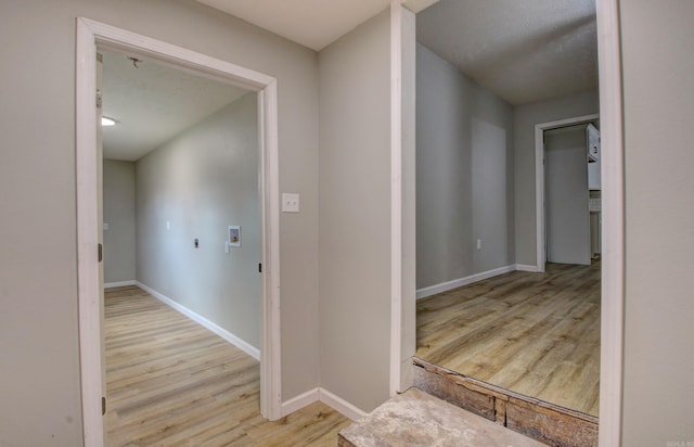 corridor featuring wood finished floors and baseboards