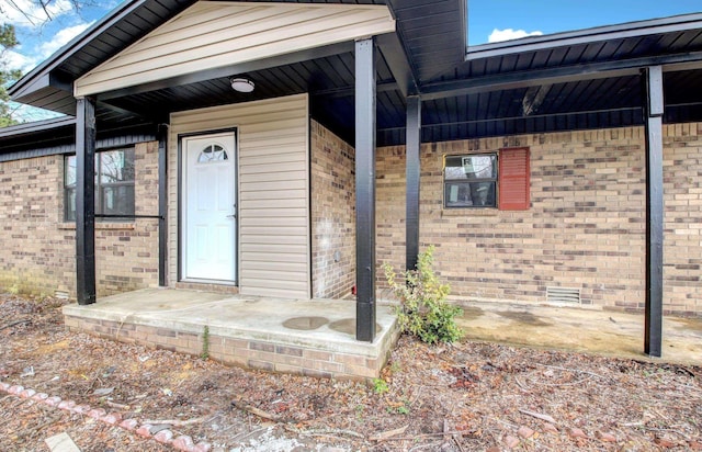 view of exterior entry with brick siding