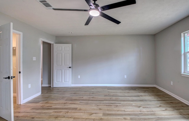 empty room with light wood-type flooring, baseboards, and a ceiling fan