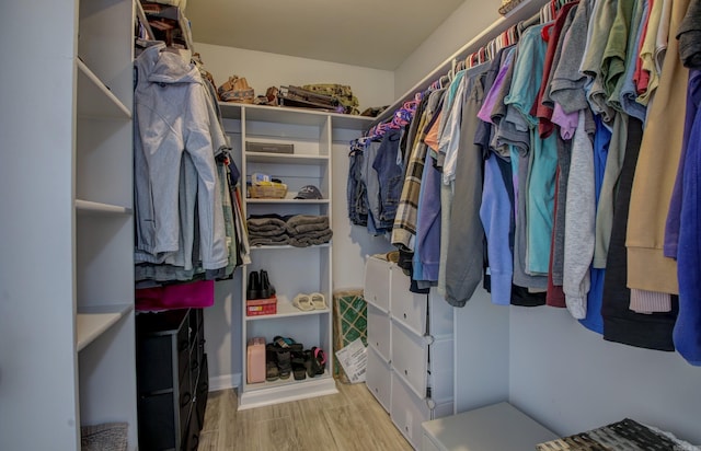walk in closet with wood finished floors