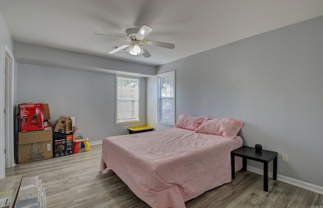 bedroom with wood finished floors, baseboards, and a ceiling fan