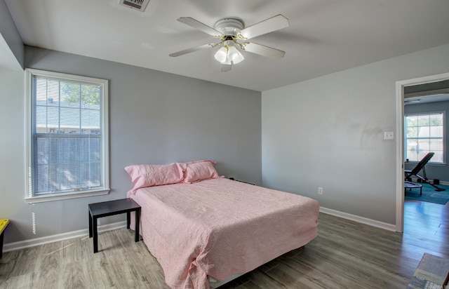 bedroom featuring wood finished floors, baseboards, and a ceiling fan