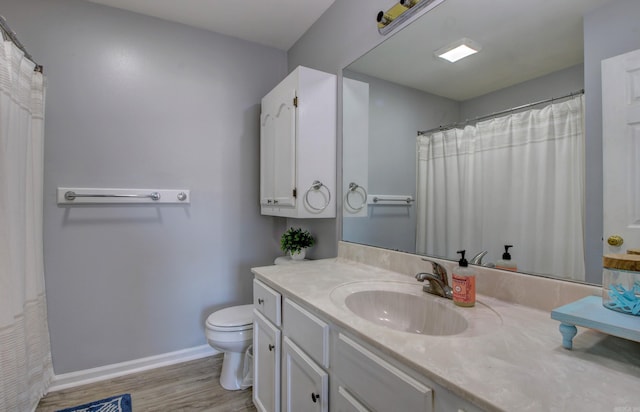 full bath with wood finished floors, baseboards, toilet, and vanity
