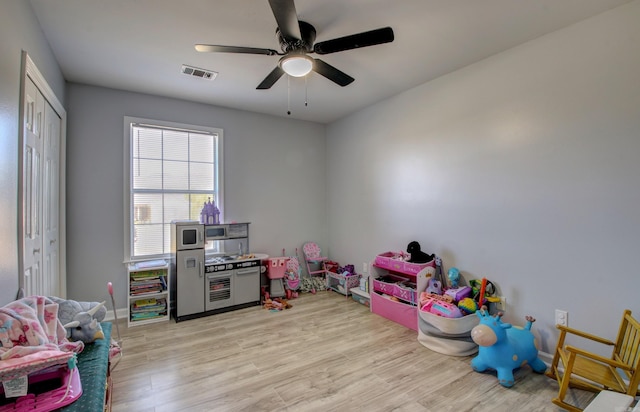 game room with light wood-type flooring, ceiling fan, and baseboards