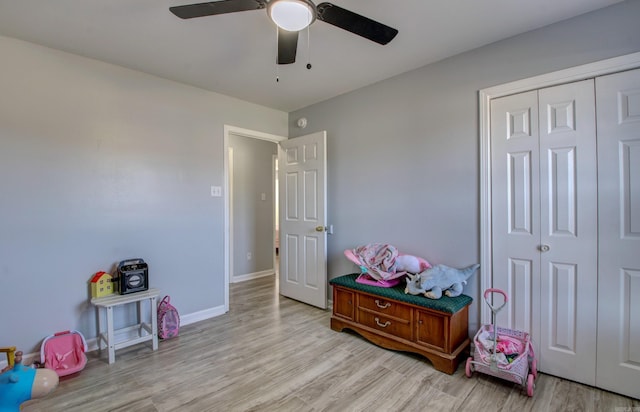 recreation room with a ceiling fan, light wood finished floors, and baseboards