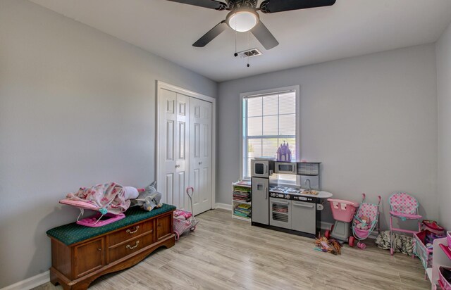 playroom featuring a ceiling fan, light wood-style floors, and baseboards