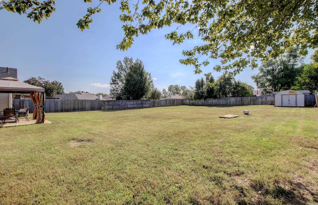 view of yard with a storage shed, a gazebo, an outdoor structure, and a patio