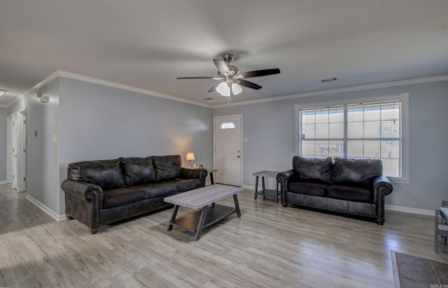 living area featuring ceiling fan, wood finished floors, healthy amount of natural light, ornamental molding, and baseboards