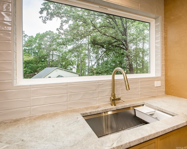 9008 Leatrice Dr, Little Rock, AR 72227 - kitchen view of decorative backsplash, a sink, and light stone countertops