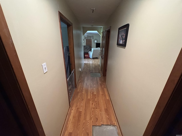 hallway with light wood-type flooring and arched walkways