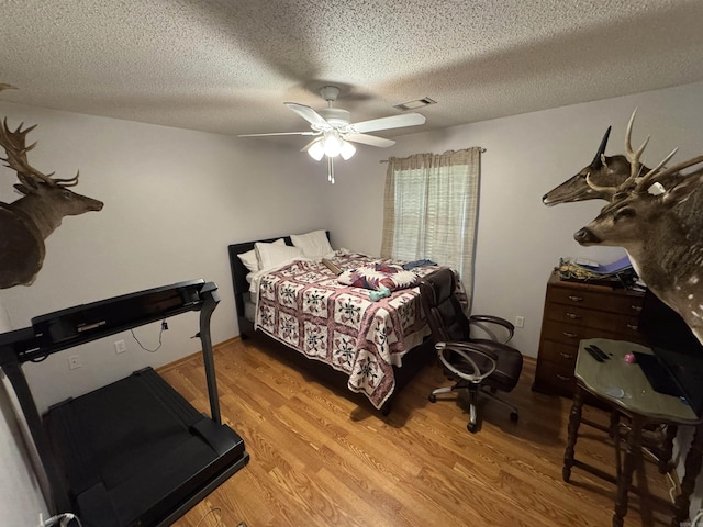 bedroom with wood finished floors, a textured ceiling, and ceiling fan