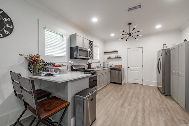 1626 Logan St, Arkadelphia, AR 71923 - kitchen with stainless steel appliances, open shelves, gray cabinetry, light wood-style flooring, and ornamental molding
