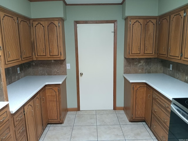 162 Cloverdale, Searcy, AR 72143 - kitchen featuring tasteful backsplash, brown cabinets, light countertops, baseboards, and light tile patterned floors