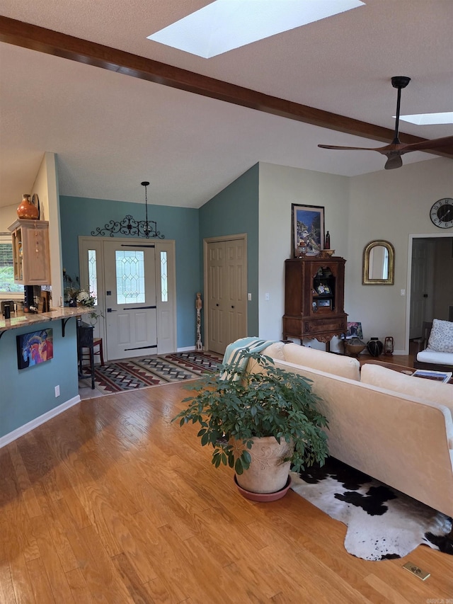 76 Justa Via Way, Hot Springs Village, AR 71909 - living room featuring a skylight, beam ceiling, wood finished floors, healthy amount of natural light, and baseboards