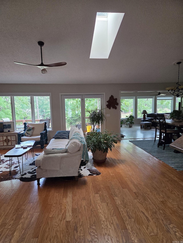 76 Justa Via Way, Hot Springs Village, AR 71909 - living area with wood finished floors, a chandelier, a ceiling fan, a textured ceiling, and a skylight