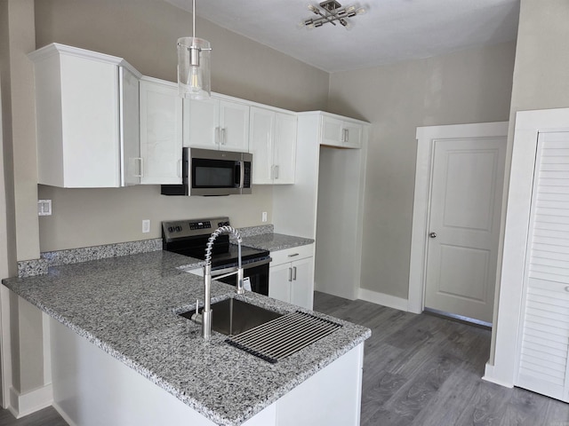 1017 Jefferson, Little Rock, AR 72204 - kitchen featuring appliances with stainless steel finishes, dark wood finished floors, light stone counters, a peninsula, and white cabinets