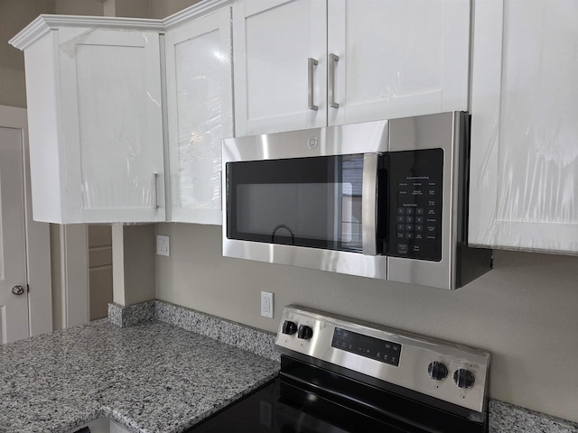 1017 Jefferson, Little Rock, AR 72204 - kitchen with appliances with stainless steel finishes, white cabinetry, and light stone countertops