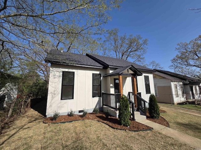 1017 Jefferson, Little Rock, AR 72204 - view of front facade with roof with shingles, a front yard, crawl space, and board and batten siding