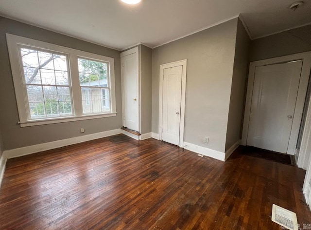 3224 W 11th St, Little Rock, AR 72204 - unfurnished bedroom with dark wood-style floors, baseboards, ornamental molding, and a closet