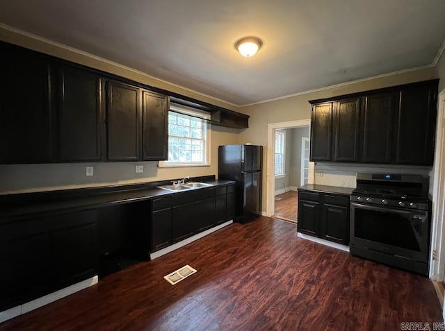3224 W 11th St, Little Rock, AR 72204 - kitchen with gas range, freestanding refrigerator, crown molding, dark wood finished floors, and a sink
