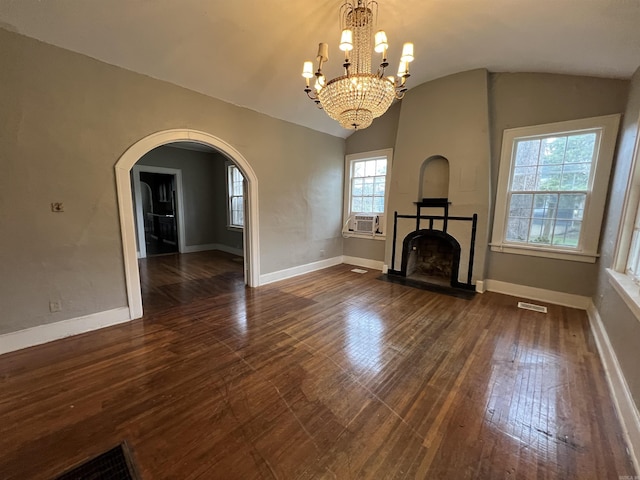3224 W 11th St, Little Rock, AR 72204 - unfurnished living room with dark wood-style flooring, arched walkways, lofted ceiling, baseboards, and a fireplace with flush hearth