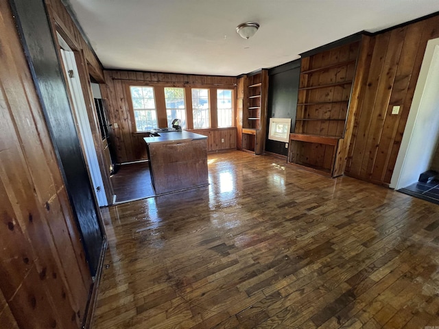 3224 W 11th St, Little Rock, AR 72204 - unfurnished living room featuring dark wood-style floors, wooden walls, and built in shelves