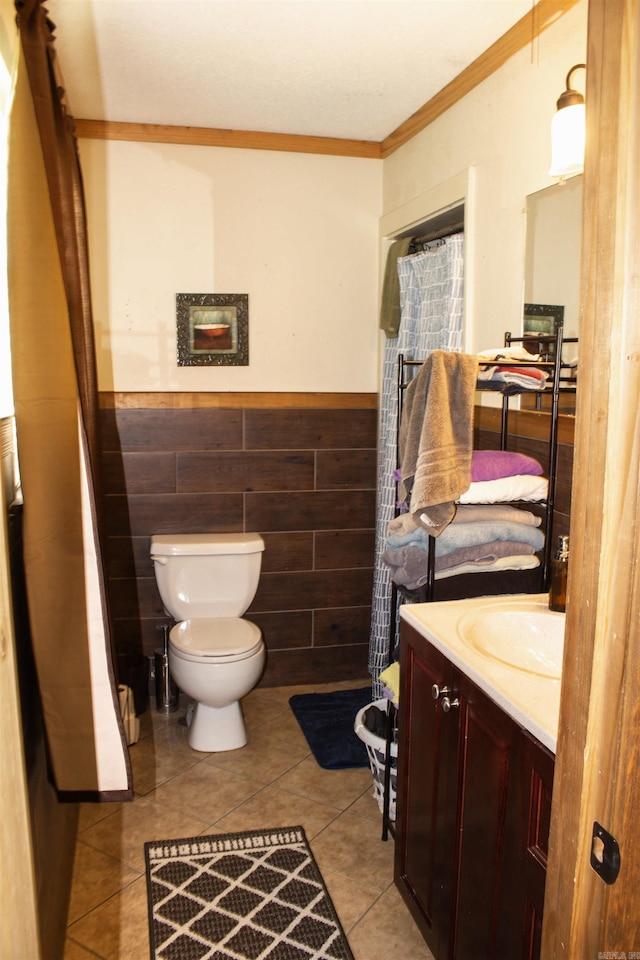 100 Elizabeth St, Prescott, AR 71857 - bathroom featuring vanity, toilet, ornamental molding, tile patterned flooring, and wainscoting