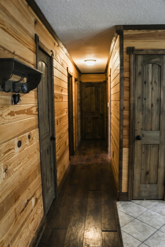 100 Elizabeth St, Prescott, AR 71857 - hall with wood walls, a textured ceiling, hardwood / wood-style flooring, a barn door, and crown molding