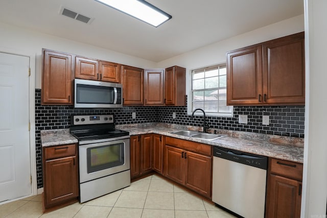 3516 Vickie Dr, Bryant, AR 72022 - kitchen with appliances with stainless steel finishes, a sink, light tile patterned floors, and backsplash