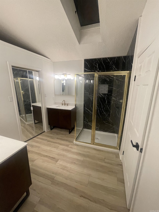 11808 Saint Charles Blvd, Little Rock, AR 72211 - bathroom featuring a textured ceiling, vanity, wood finished floors, and a marble finish shower