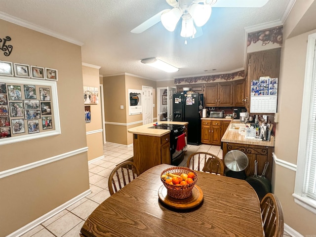 53 White Oak Cir, Searcy, AR 72143 - dining space with light tile patterned floors, ceiling fan, baseboards, estacked washer and dryer, and ornamental molding