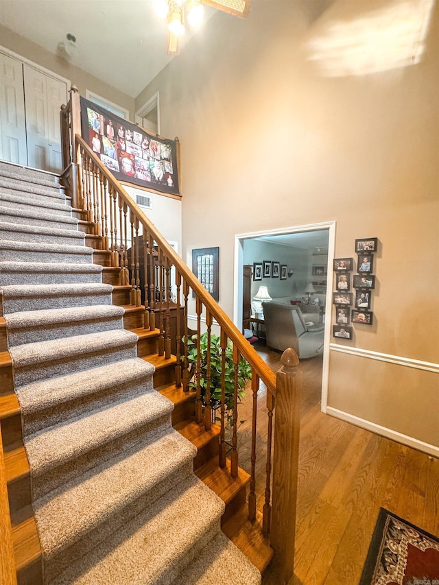 53 White Oak Cir, Searcy, AR 72143 - stairs with wood finished floors, a ceiling fan, baseboards, and a high ceiling