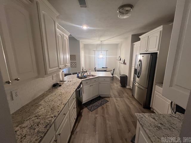 1808 Hidden Crk, Sherwood, AR 72120 - kitchen with stainless steel fridge, a peninsula, white cabinetry, and dark wood-style flooring