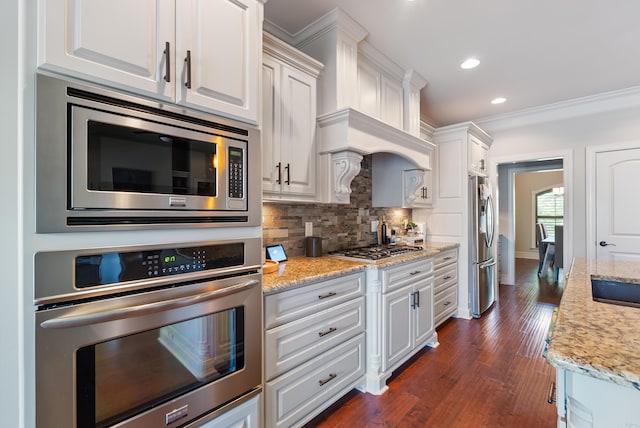 43 Tournay Cir, Little Rock, AR 72223 - kitchen with stainless steel appliances, white cabinetry, tasteful backsplash, dark wood-style floors, and light stone countertops