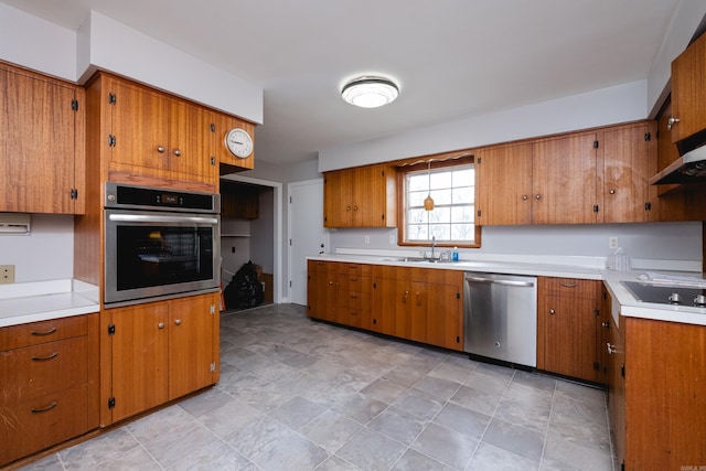 17 Wingate Dr, Little Rock, AR 72205 - kitchen featuring appliances with stainless steel finishes, brown cabinetry, a sink, and light countertops